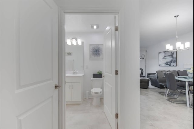 bathroom featuring vanity, toilet, a chandelier, and tile patterned flooring