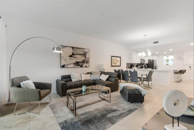 tiled living room featuring an inviting chandelier and sink