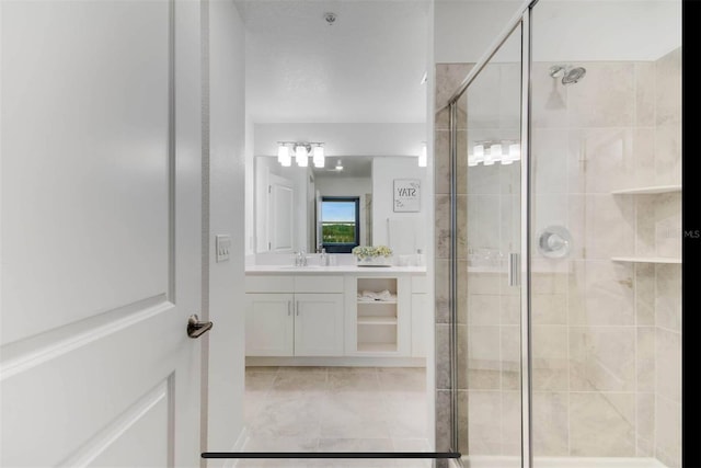 bathroom with vanity, a shower with shower door, and tile patterned flooring