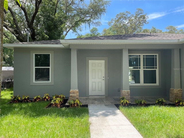 entrance to property with a lawn