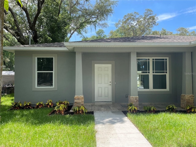 1730 Old Apopka Rd, Apopka, FL 32703 - entrance to property with stucco siding, a yard, a shingled roof, and stone siding