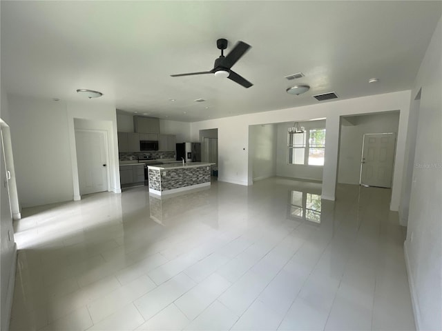 unfurnished living room with ceiling fan and sink