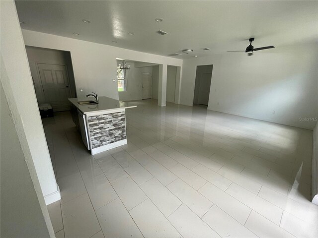 spare room with ceiling fan with notable chandelier, light tile patterned floors, and sink