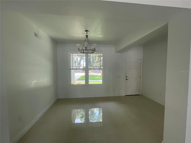 unfurnished room featuring a notable chandelier