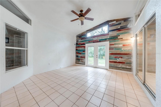 empty room with french doors, light tile patterned floors, ceiling fan, and lofted ceiling