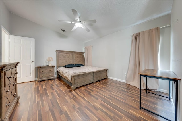 bedroom with a textured ceiling, ceiling fan, dark hardwood / wood-style flooring, and lofted ceiling