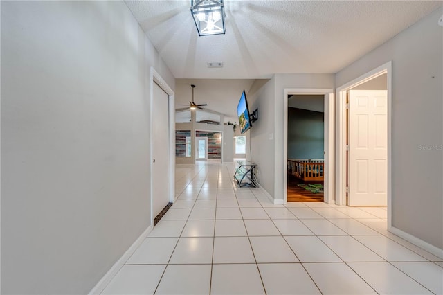 corridor with light tile patterned floors and a textured ceiling