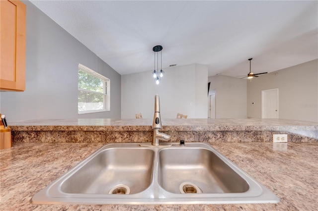 interior details with ceiling fan, sink, hanging light fixtures, and light brown cabinets