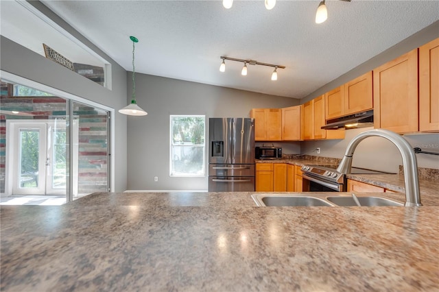 kitchen with pendant lighting, light brown cabinets, lofted ceiling, a textured ceiling, and stainless steel appliances