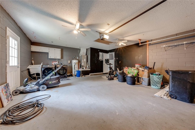 interior space with heating unit, ceiling fan, a garage door opener, and water heater