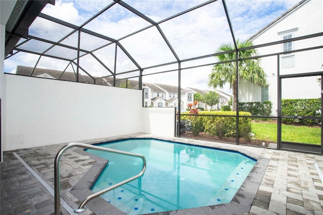 view of swimming pool with a patio area and glass enclosure