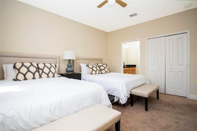 bedroom featuring ensuite bathroom, carpet flooring, ceiling fan, and a closet