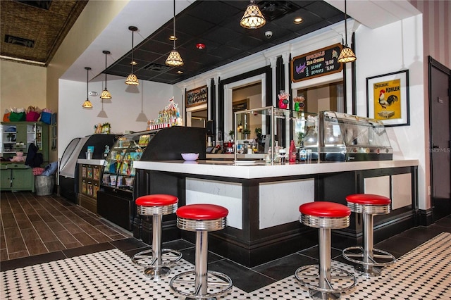 bar featuring pendant lighting and crown molding