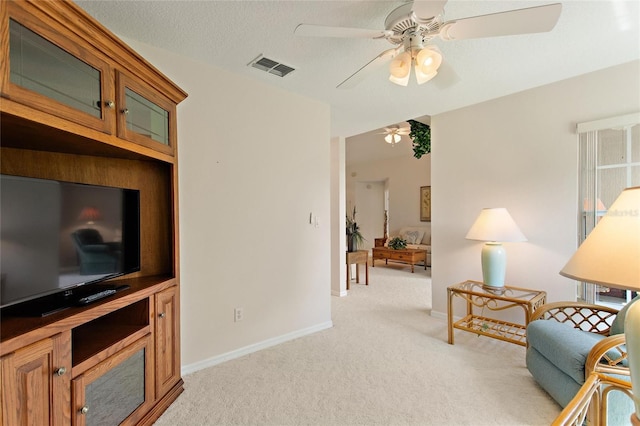 carpeted living room featuring ceiling fan