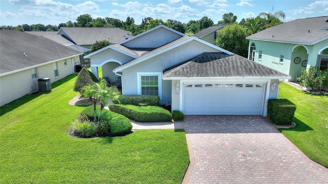 view of front of property with cooling unit, a garage, and a front yard