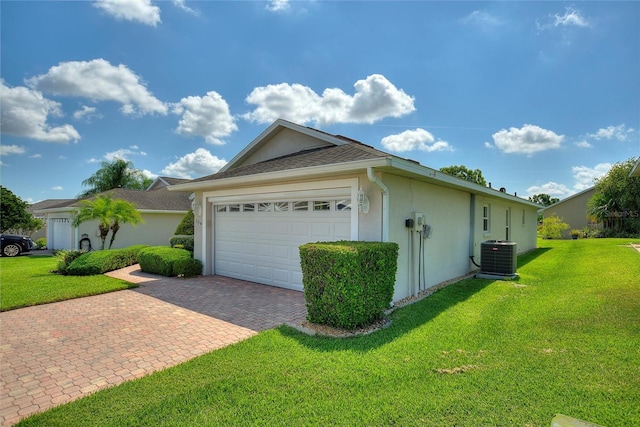 view of home's exterior with a lawn, central AC unit, and a garage