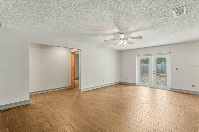 unfurnished room with french doors, ceiling fan, light wood-type flooring, a textured ceiling, and a baseboard radiator