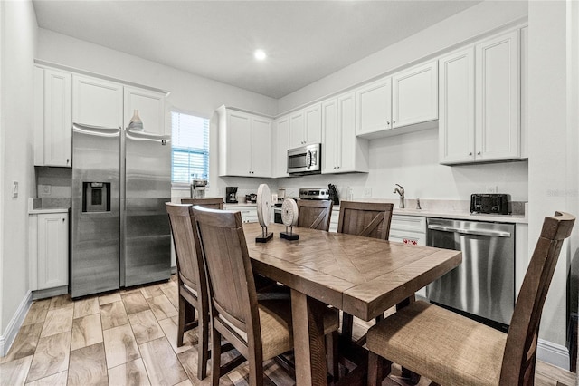 kitchen featuring appliances with stainless steel finishes, white cabinetry, and sink