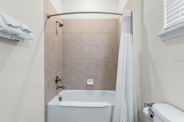 bathroom featuring shower / bath combo with shower curtain and toilet