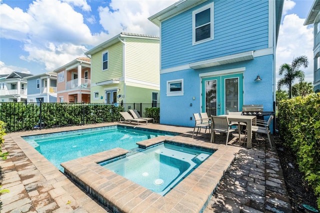 view of pool with a patio, an in ground hot tub, and grilling area