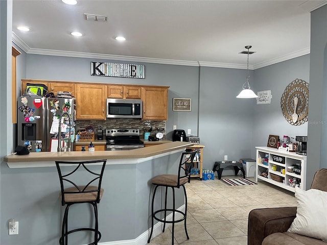 kitchen featuring appliances with stainless steel finishes, decorative light fixtures, a breakfast bar, light tile patterned floors, and ornamental molding