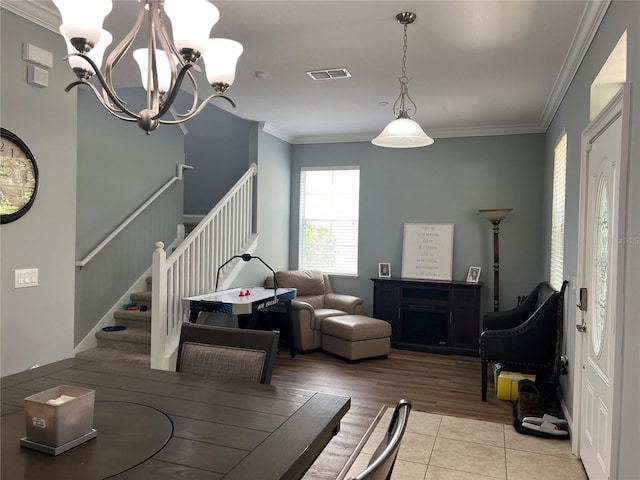 dining space with a chandelier, light hardwood / wood-style floors, and ornamental molding