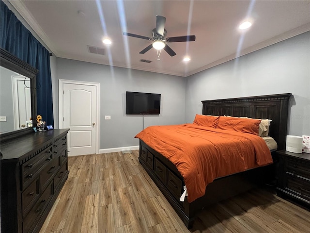 bedroom featuring ceiling fan, crown molding, and light hardwood / wood-style flooring