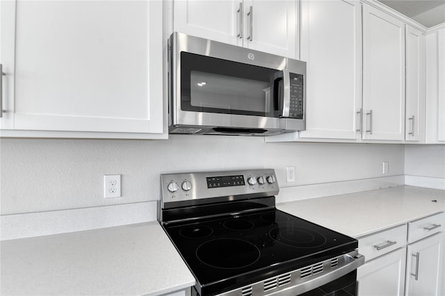 kitchen featuring white cabinets, light stone countertops, and appliances with stainless steel finishes