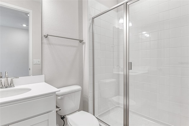 bathroom featuring vanity, toilet, and an enclosed shower