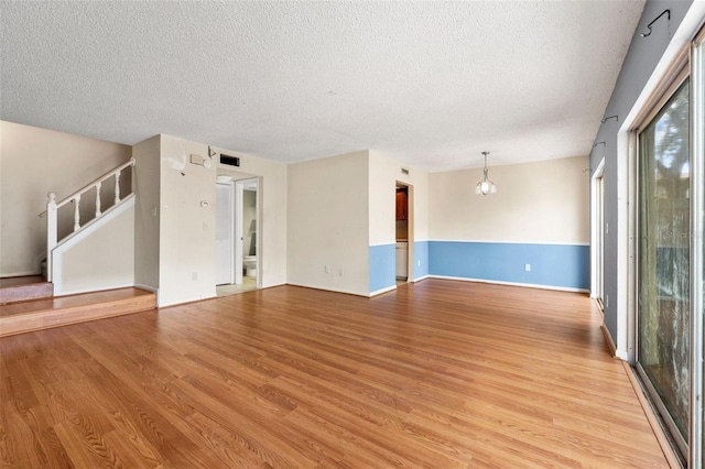 spare room with light hardwood / wood-style flooring and a textured ceiling