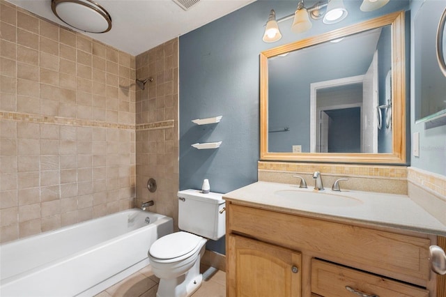 full bathroom featuring tile patterned flooring, vanity, tiled shower / bath combo, and toilet