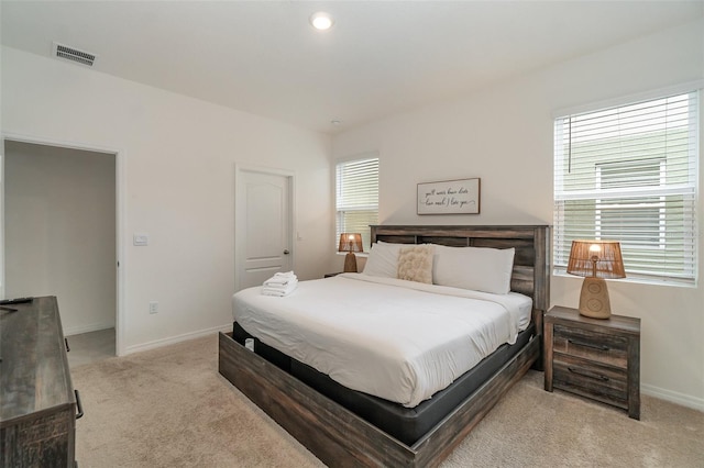 carpeted bedroom featuring multiple windows