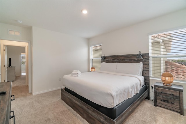 bedroom featuring light carpet and multiple windows