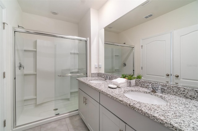 bathroom with tile patterned flooring, vanity, and walk in shower