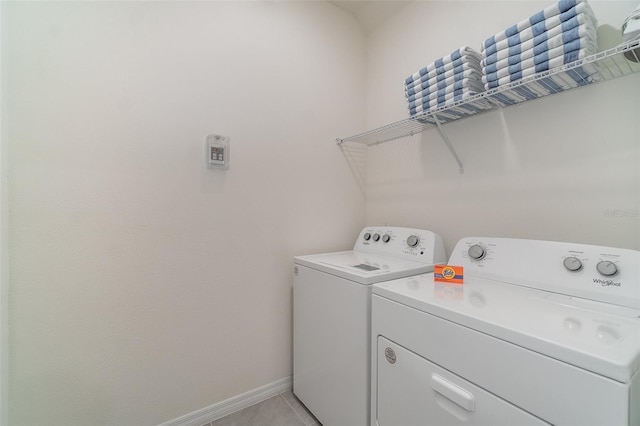 laundry area with washer and clothes dryer and light tile patterned flooring