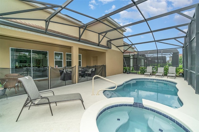 view of pool with glass enclosure, an in ground hot tub, and a patio