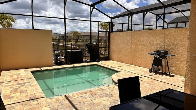 view of pool with grilling area, a lanai, and a patio