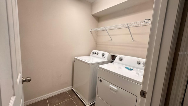 washroom with washing machine and clothes dryer and dark tile patterned floors