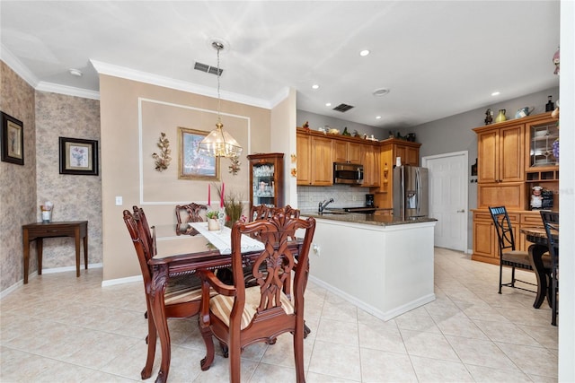 dining room featuring sink, light tile patterned floors, ornamental molding, and a chandelier