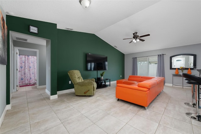 living room featuring ceiling fan, light tile patterned floors, and vaulted ceiling