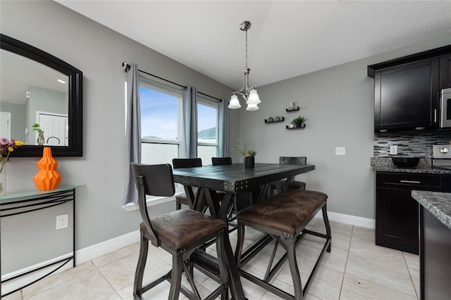 tiled dining room with a chandelier