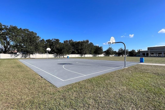 view of sport court featuring a lawn