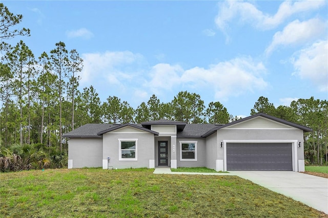 view of front of property featuring a garage, driveway, a front lawn, and stucco siding