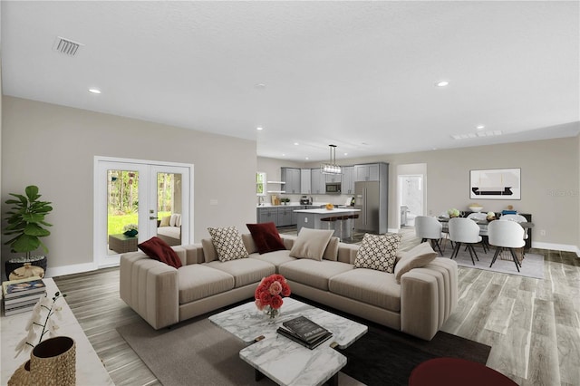 living area with light wood-type flooring, recessed lighting, french doors, and visible vents