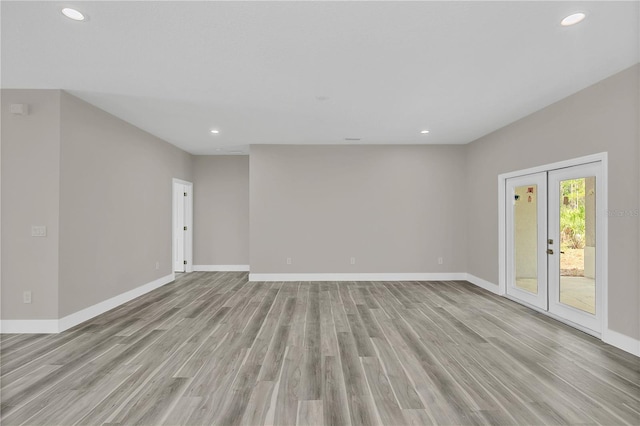 spare room featuring baseboards, french doors, recessed lighting, and light wood-style floors