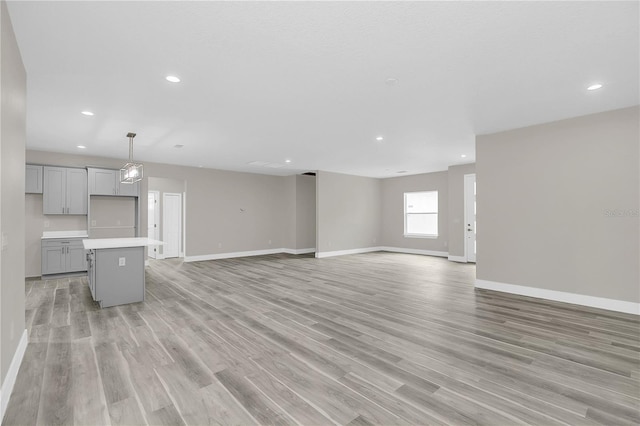 unfurnished living room with light wood-style flooring, baseboards, and recessed lighting