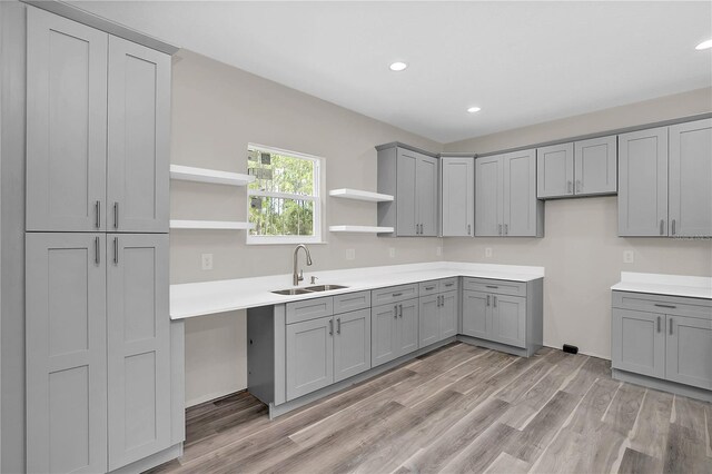 kitchen featuring light countertops, a sink, and gray cabinetry