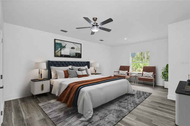 bedroom featuring wood finished floors, visible vents, and baseboards