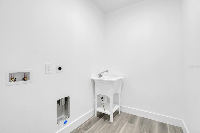 laundry area featuring hookup for a washing machine, electric dryer hookup, light wood-type flooring, laundry area, and baseboards