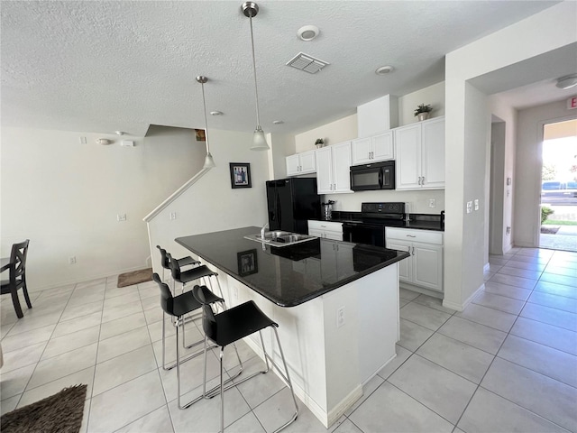 kitchen with a center island, black appliances, white cabinets, decorative light fixtures, and a kitchen bar